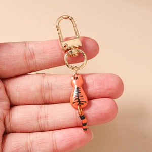 Detailed view of the orange striped enamel cat keychain with golden alloy lobster clasp