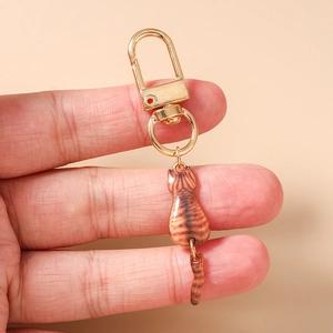 Detailed close-up of a brown tabby cat keychain charm with gold metal hardware