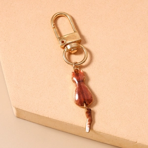 Detail of cute cat keychain with gold lobster clasp and brown resin cat pendant for bags