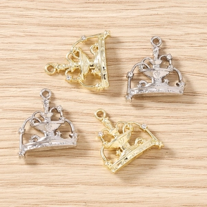 Macro shot of crown fountain enamel pendants with inlaid crystals on wooden background