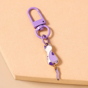 Close-up of purple enamel cat keychain with articulated tail and purple metallic D-ring