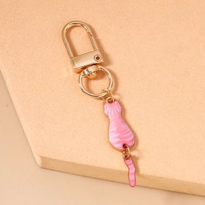 Detailed shot of golden keychain featuring a pink striped cat with movable tail design