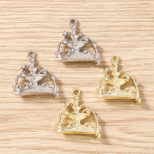 Detailed view of four fountain-shaped charms in gold and silver with sparkling rhinestones