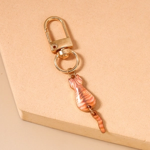 Close-up of cute orange striped cat keychain with a flexible tail and gold metal clasp