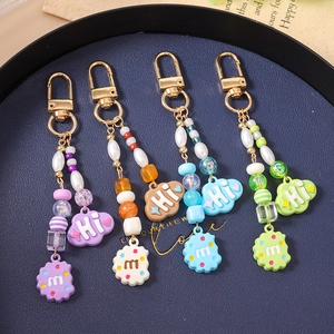 Detailed close-up of handmade beaded keychains with colorful cloud and cookie pendants