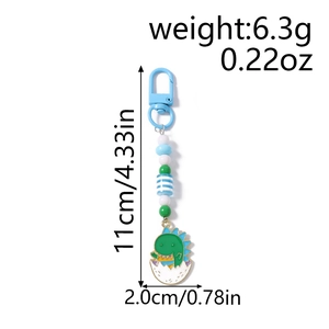 Detail view of cartoon dinosaur egg keychain with colorful beads and dimension labels