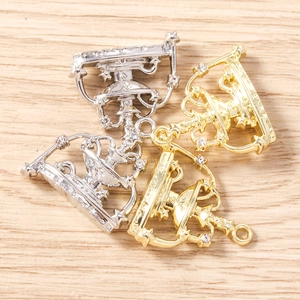 Macro shot of crown-shaped DIY pendants in gold and silver with sparkling rhinestones