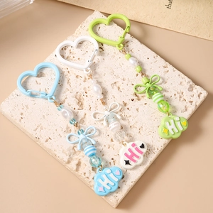 Détail de porte-clés à perles en forme de cœur avec nœuds colorés et nuages