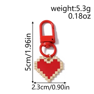 Macro detail of red pixel heart keychain with gold edges and lobster clasp accessory