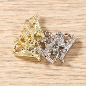Macro detail of crown shaped metal alloy charms with crystal rhinestones for DIY jewelry