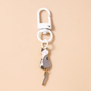 Close-up of cute cartoon cat keychain with swinging tail detail and white metal clip