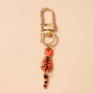Detailed view of an orange cat keychain with a swinging tail and gold lobster clasp