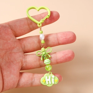 Détail du porte-clés perlé avec fermoir coeur vert et un pendentif nuage mignon marqué Hi