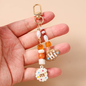 Detailed shot of beaded keychain featuring a brown cloud and cream biscuit pendant