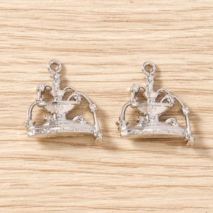 Detailed macro view of two silver fountain crown charms with polished alloy finish and loop