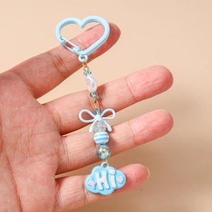 Détail d'un porte-clés perlé bleu clair avec fermoir cœur et charm nuage marqué HI