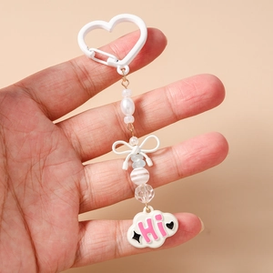 Détail d'un porte-clés à perles et nœud avec pendentif nuage et clip en cœur