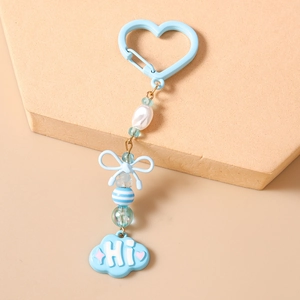 Détail d'un porte-clés bleu clair perlé avec nœud décoratif et pendentif nuage Hi