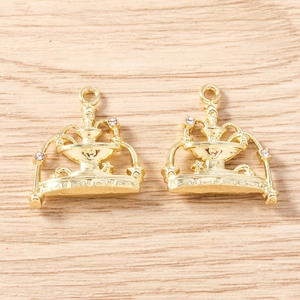 Detailed close-up of golden crown pendants with small rhinestones for DIY jewelry
