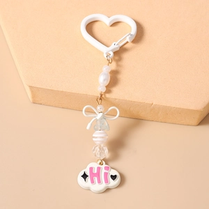 Gros plan du porte-clés à perles blanches avec un nœud et un pendentif nuage lettré Hi