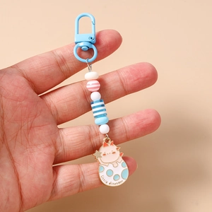 Detail of cute little dinosaur enamel pendant with colorful acrylic beads and blue hook