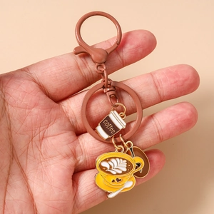 Detail of coffee theme enamel keychain with latte cup and coffee bean charms