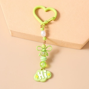 Détail du porte-clés perlé vert clair avec nœud papillon et pendentif nuage mignon