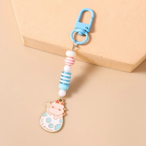 Detail of cute pink dinosaur egg keychain with colorful beads and a blue clasp