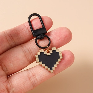 Macro shot of mosaic pixel heart keychain with black metal D-ring clasp held in hand