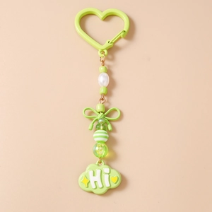 Détail d'un porte-clés perlé avec un nœud vert et un pendentif en forme de nuage