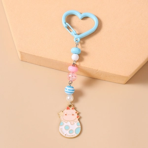 Détail du porte-clés perlé avec perles macaron et un petit pendentif dinosaure émaillé