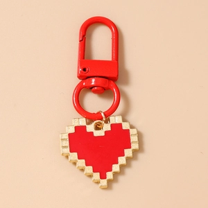 Detail of red 8-bit pixel heart keychain with metallic U-shaped hook and gold edges