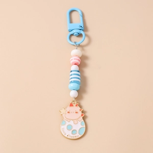 Close-up of cute pink dinosaur enamel pendant and colorful beads on a light blue keychain