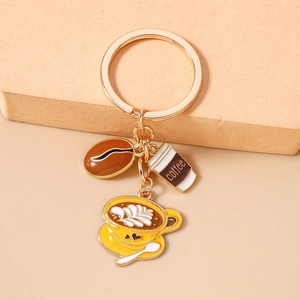 Close-up of golden keychain with coffee bean and latte cup enamel charms in high detail