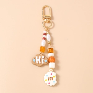 Detail of beaded keychain with gold lobster clasp, cookies, and cloud letter charms