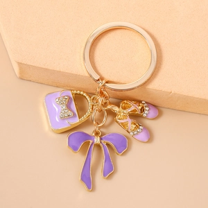 Detail of purple enamel handbag and ballet shoes keychain with sparkling rhinestones