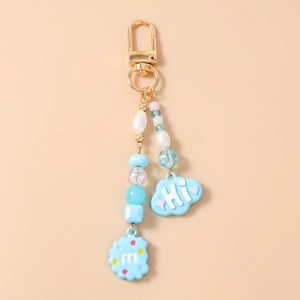 Close-up of beaded keychain with blue cloud Hi and cookie m charms on golden lobster clasp