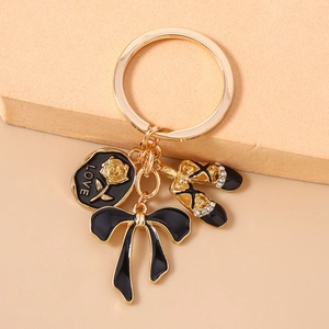 Macro detail of enamel LOVE charm with golden rose, ballet shoes, and black ribbon