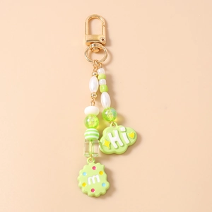 Detailed view of beaded food keychain with green cookie charm and hi cloud pendant