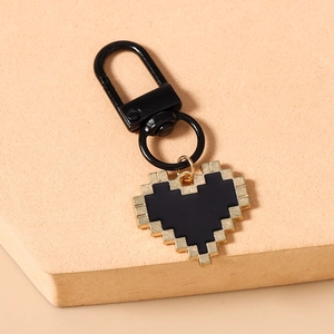 Detail of pixel heart keychain with gold metal edges and black spring buckle