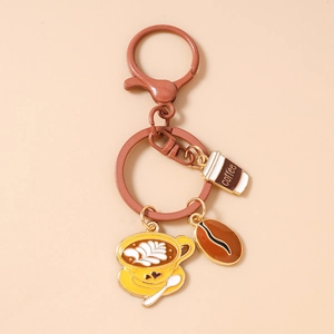 Close-up of coffee bean keychain with gold-plated latte cup and coffee cup pendants