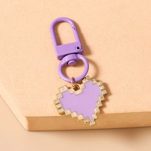 Detail of purple pixelated heart keychain with golden frame and lobster clasp