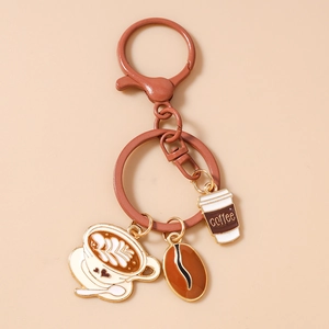 Detail of coffee bean and latte cup charms on a gold metal keychain pendant