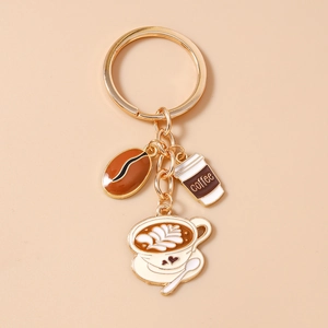 Close-up of golden coffee bean and latte cup charms on a stylish metal keychain