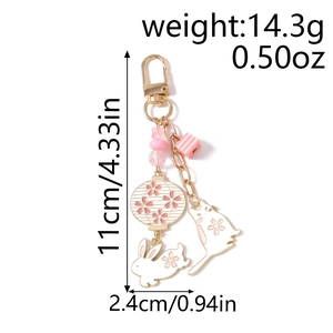 Detail view of cat and rabbit lantern keychain with measurement lines and product weight