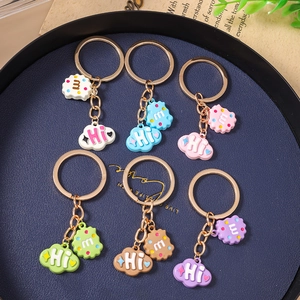 Set of 6 colorful keychains with cloud and biscuit charms on a blue tray for bag decoration