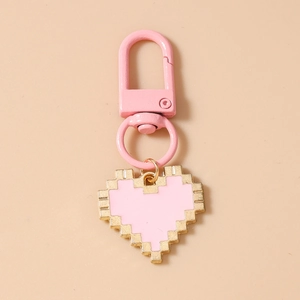 Macro detail of pixelated heart keychain with pink alloy drip oil and golden metallic trim