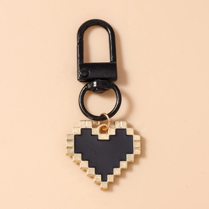 Detail of pixel heart keychain with black matte carabiner on a soft pink background