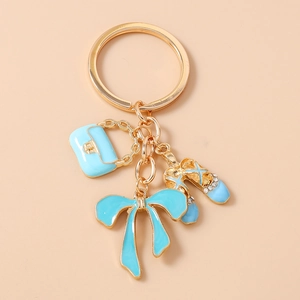 Detail of blue enamel handbag and rhinestone ballet shoes charms on a gold keychain