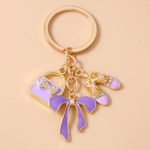 Detail of purple rhinestone bag and ballet shoes pendants on gold key chain